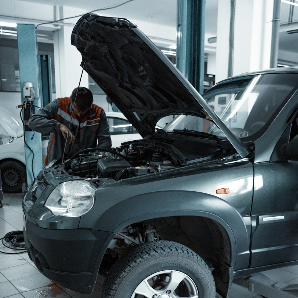 Mechanic repairing a raised vehicle in a workshop